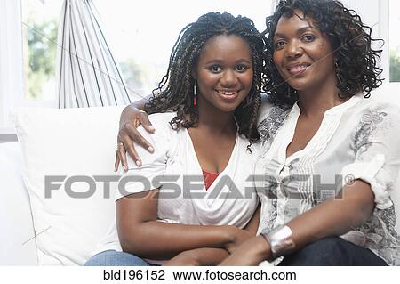 Black mother and daughter hugging on sofa View Large Photo Image Stock Image - Black mother and daughter hugging on sofa. Fotosearch
