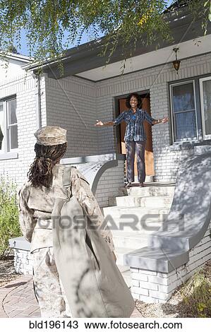 Stock Image - Black mother greeting soldier daughter. Fotosearch