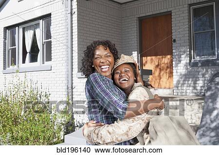 Stock Image - Black mother hugging soldier daughter. Fotosearch