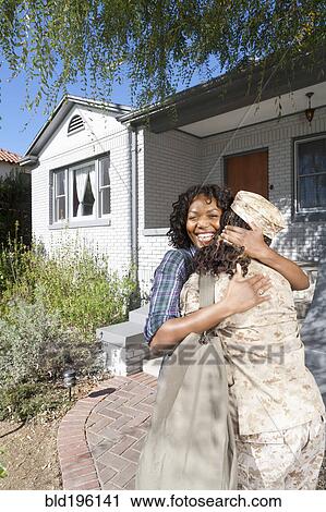Stock Image - Black mother hugging soldier daughter. Fotosearch