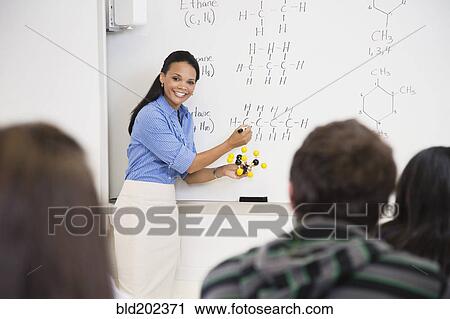 Stock Image - Black teacher explaining chemistry model to students. Fotosearch
