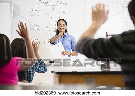 Stock Photo - Black teacher talking to students in class room. Fotosearch