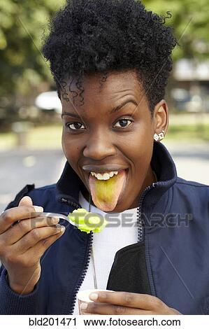 Stock Image - Black woman eating ice cream. Fotosearch
