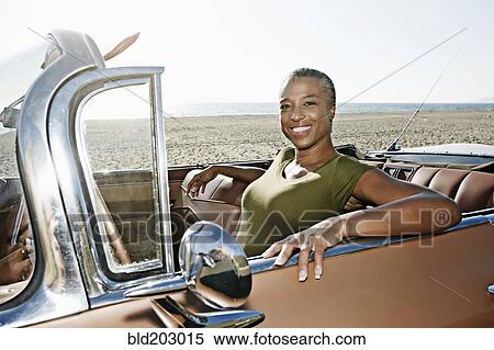 Stock Photography - Black woman sitting in convertible. Fotosearch