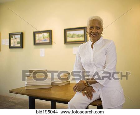Black woman sitting on table View Large Photo Image Picture - Black woman sitting on table. Fotosearch
