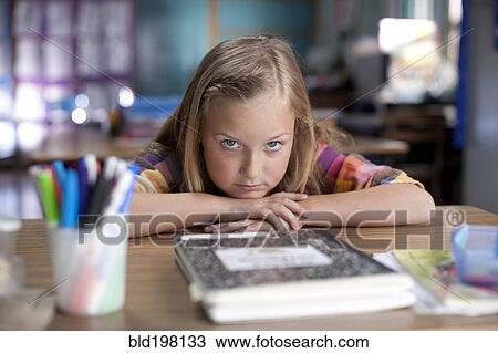 Stock Image - Bored Caucasian girl sitting in classroom. Fotosearch