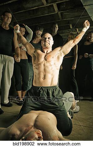 Stock Image - Boxer cheering after beating opponent. Fotosearch