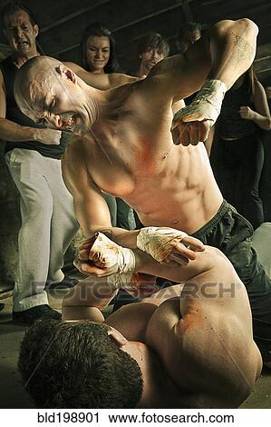 Stock Image - Boxer hitting opponent who's laying on floor. Fotosearch