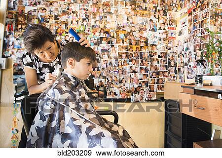 Stock Photo - Boy having hair cut in salon. Fotosearch