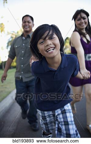 Boy laughing and pulling mother and father View Large Photo Image Stock Image - Boy laughing and pulling mother and father. Fotosearch