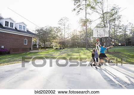 Stock Image - Boys playing basketball. Fotosearch