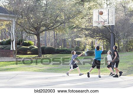 Stock Image - Boys playing basketball. Fotosearch