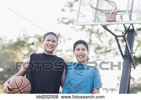 Stock Photo - Boys playing basketball. Fotosearch