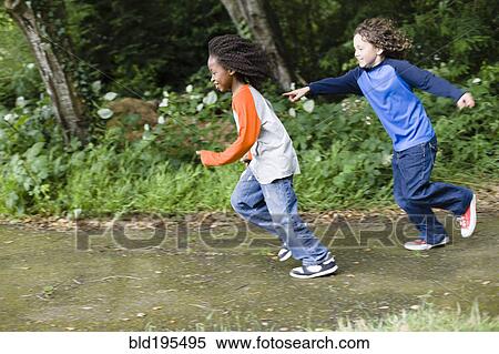 Stock Photography - Boys playing tag in the park. Fotosearch