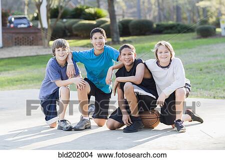 Picture - Boys sitting with basketball. Fotosearch