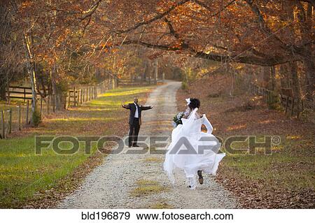 Bride and groom running to each other on path View Large Photo Image Stock Photo - Bride and groom running to each other on path. Fotosearch