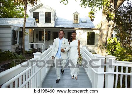 Stock Image - Bride and groom walking together after wedding. Fotosearch