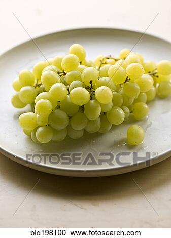 Stock Image - Bunch of green grapes on plate. Fotosearch
