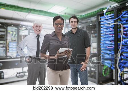 Business people standing in server room View Large Photo Image Stock Photo - Business people standing in server room. Fotosearch