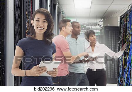Stock Photograph - Business people standing in server room. Fotosearch