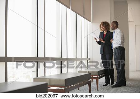 Business people talking together near window View Large Photo Image Stock Photo - Business people talking together near window. Fotosearch