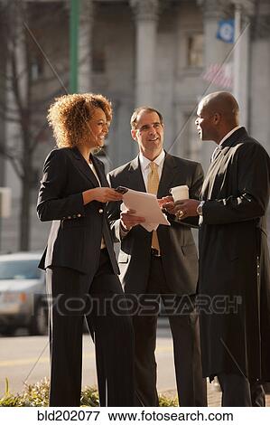 Stock Photo - Business people talking together outdoors. Fotosearch