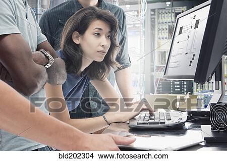 Picture - Business people working in server room. Fotosearch