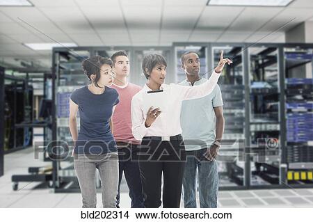 Picture - Business people working in server room. Fotosearch