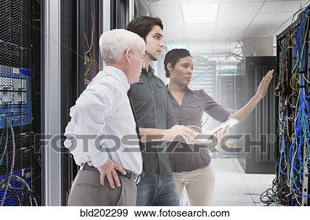 Business people working in server room View Large Photo Image Stock Photo - Business people working in server room. Fotosearch