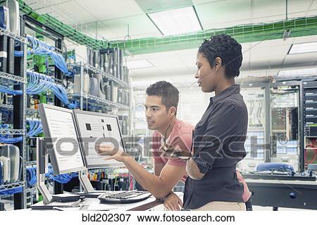 Stock Photo - Business people working in server room. Fotosearch