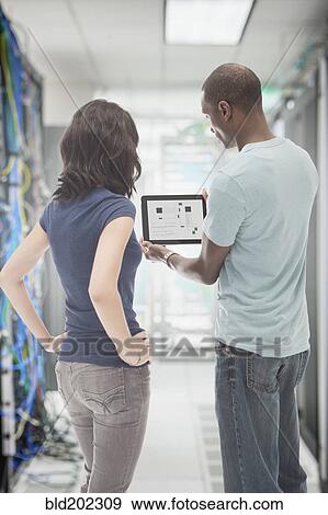 Stock Photo - Business people working in server room. Fotosearch