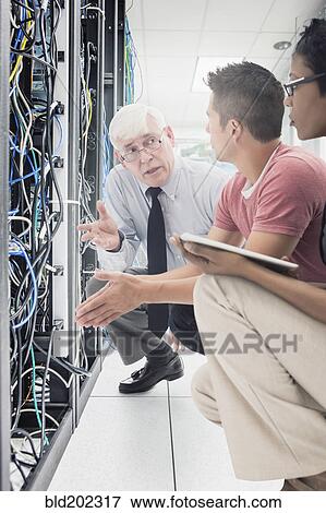Stock Photo - Business people working in server room. Fotosearch