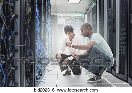 Stock Photograph - Business people working in server room. Fotosearch