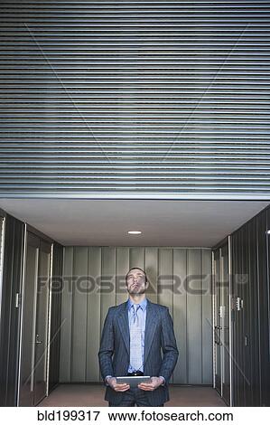 Businessman using digital tablet in corridor View Large Photo Image Stock Photo - Businessman using digital tablet in corridor. Fotosearch