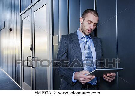 Stock Image - Businessman using digital tablet outdoors. Fotosearch