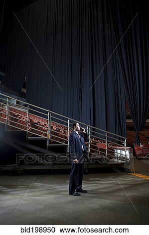 Businessman using walkie-talkie in empty auditorium View Large Photo Image Stock Image - Businessman using walkie-talkie in empty auditorium. Fotosearch