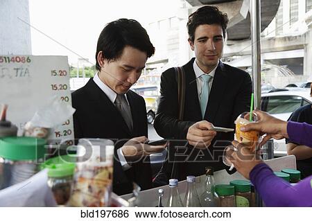 Businessmen buying lunch together at food cart View Large Photo Image Stock Photograph - Businessmen buying lunch together at food cart. Fotosearch