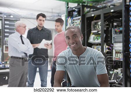 Stock Image - Businessmen in server room. Fotosearch