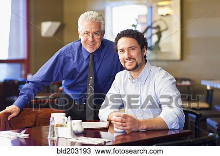 Businessmen smiling together in cafe View Large Photo Image Stock Image - Businessmen smiling together in cafe. Fotosearch