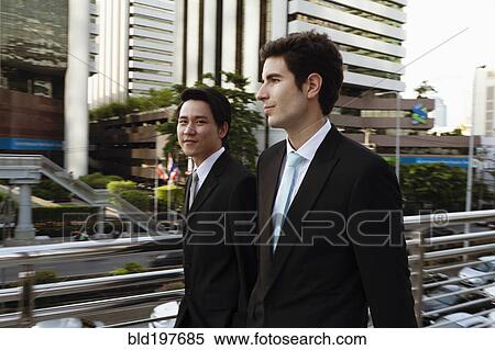 Stock Photography - Businessmen walking together outdoors. Fotosearch