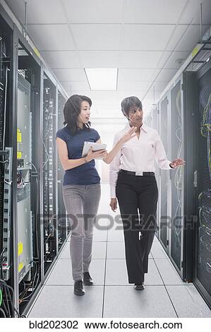 Stock Image - Businessmen working in server room. Fotosearch