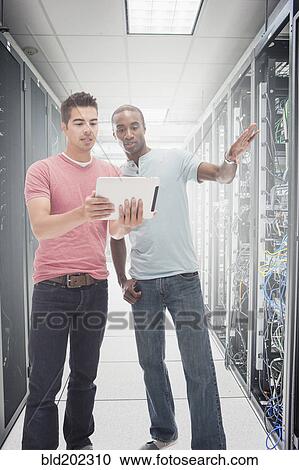 Businessmen working in server room View Large Photo Image Stock Image - Businessmen working in server room. Fotosearch