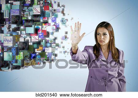Stock Image - Businesswoman holding hand out toward digital images. Fotosearch