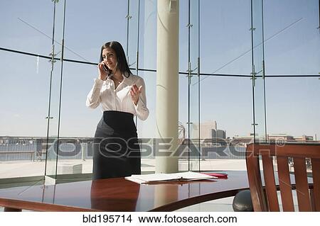 Picture - Businesswoman working in large office with glass wall. Fotosearch
