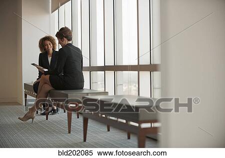 Businesswomen talking in waiting area View Large Photo Image Stock Photography - Businesswomen talking in waiting area. Fotosearch