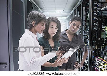 Businesswomen working together in server room View Large Photo Image Stock Photography - Businesswomen working together in server room. Fotosearch