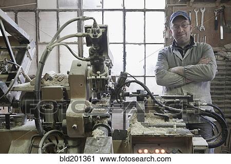 Carpenter standing near woodshop machinery View Large Photo Image Stock Image - Carpenter standing near woodshop machinery. Fotosearch