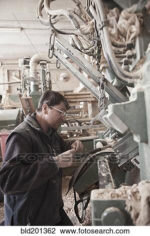 Stock Image - Carpenter working in woodshop. Fotosearch