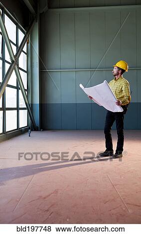 Caucasian architect reviewing blueprints View Large Photo Image Stock Photo - Caucasian architect reviewing blueprints. Fotosearch