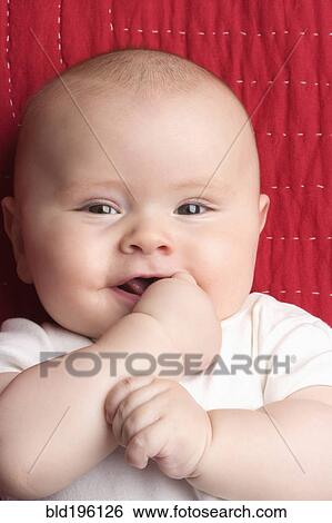 Stock Photograph - Caucasian baby biting hand. Fotosearch